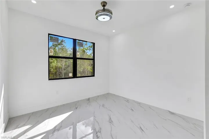 Unfurnished room with marble finish flooring and recessed lighting