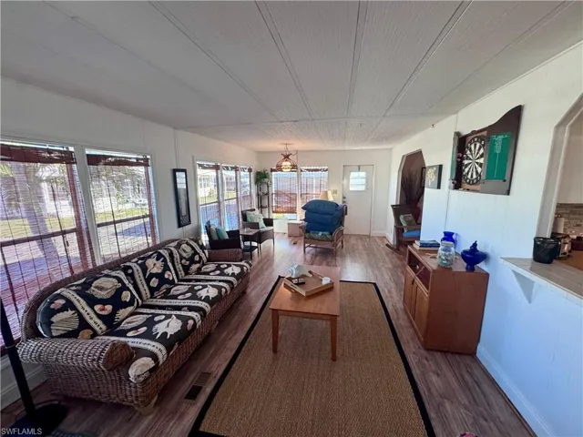 Living room with visible vents, baseboards, and wood finished floors