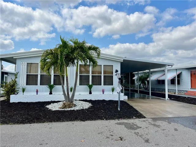 Manufactured / mobile home featuring driveway and an attached carport