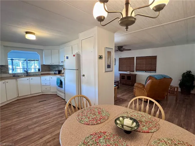 Dining space with ceiling fan, visible vents, and dark wood-type flooring