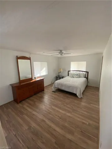 Bedroom with dark wood-type flooring and ceiling fan