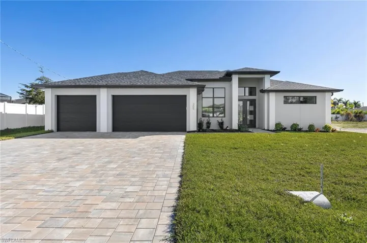Prairie-style home featuring decorative driveway, stucco siding, a garage, and roof with shingles