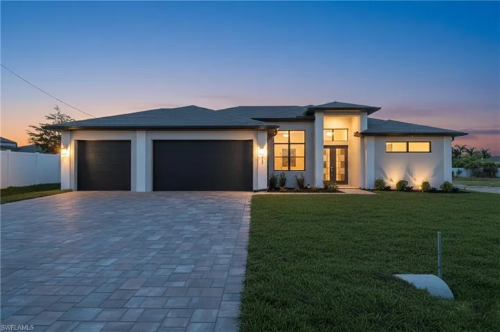 Prairie-style home with decorative driveway, a garage, and stucco siding
