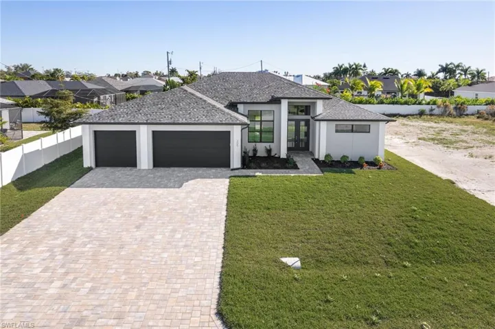View of front facade featuring decorative driveway, an attached garage, a residential view, a shingled roof, and stucco siding
