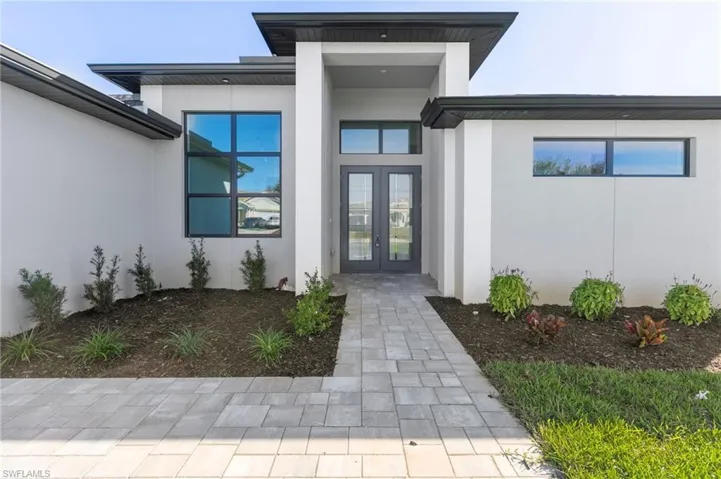 View of exterior entry with stucco siding and french doors