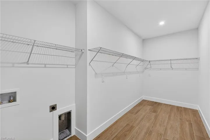 Washroom with hookup for a washing machine, light wood-style floors, electric dryer hookup, and recessed lighting