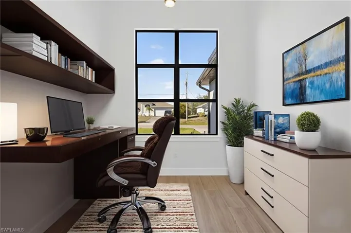 Office area with light wood-style floors and built in study area