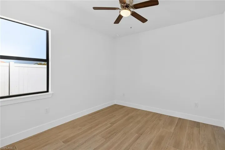 Spare room with wood tiled floors and ceiling fan
