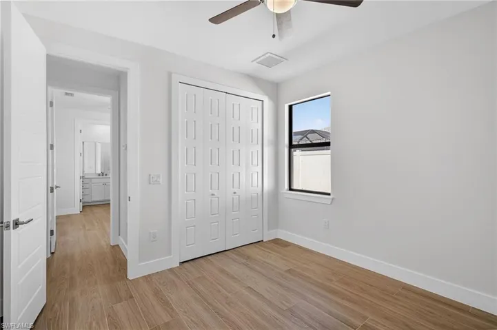 Unfurnished bedroom with light wood-style flooring, a closet, and ceiling fan