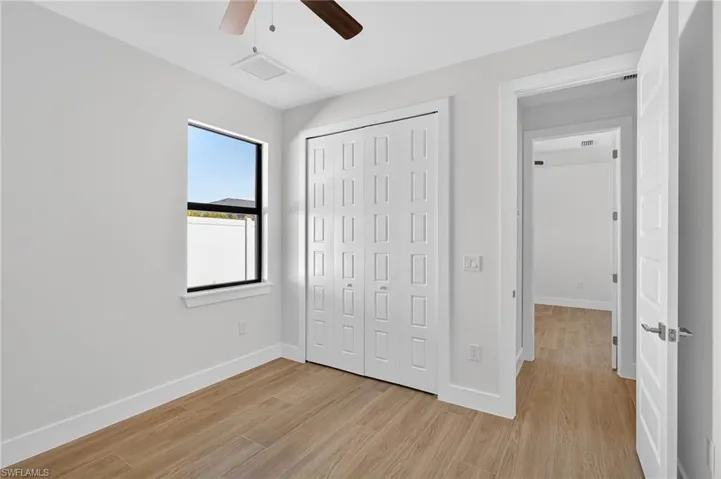 Unfurnished bedroom featuring a closet, light wood finished floors, and ceiling fan