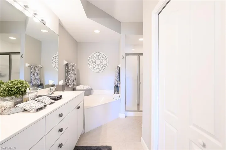 Bathroom featuring vanity, separate shower and tub, and tile patterned flooring