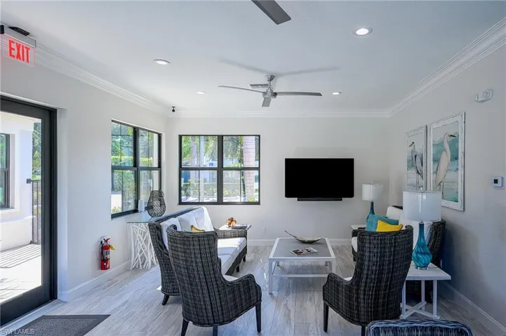 Living room featuring ceiling fan, light hardwood / wood-style flooring, and ornamental molding