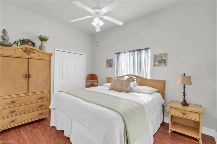 Bedroom with a closet, ceiling fan, and dark hardwood / wood-style floors