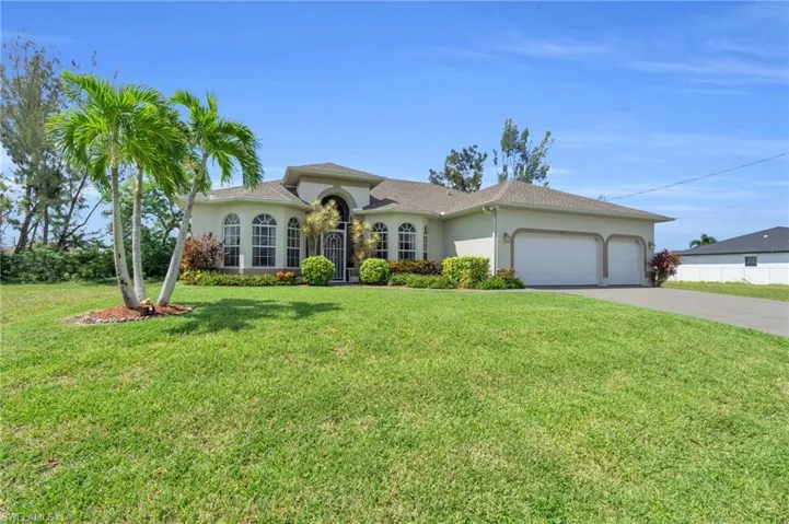 View of front facade with a garage and a front lawn
