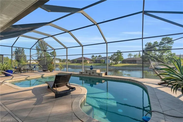 View of swimming pool with a lanai, a patio area, and a water view
