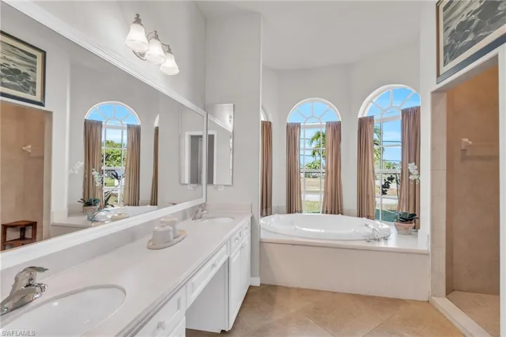 Bathroom with a high ceiling, separate shower and tub, tile patterned floors, and vanity