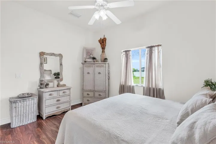 Bedroom featuring ceiling fan and dark wood-type flooring