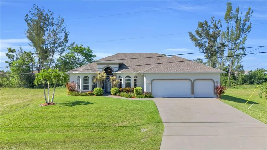View of front facade with a garage and a front lawn
