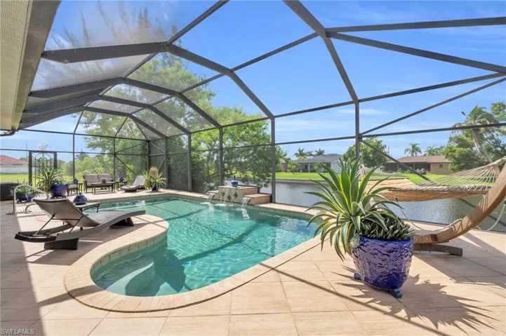 View of pool featuring pool water feature, a patio, a lanai, and a jacuzzi