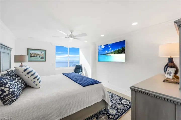 Bedroom with hardwood / wood-style flooring, ceiling fan, and crown molding