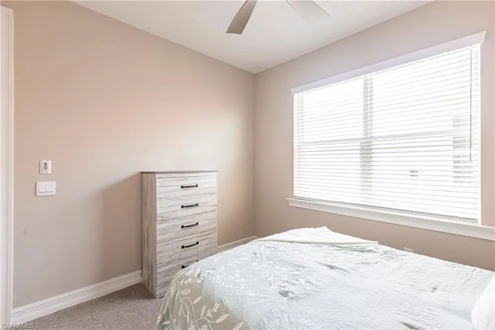 Bedroom featuring a ceiling fan, carpet, and baseboards