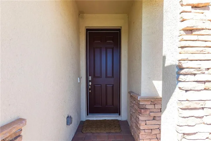 View of exterior entry with stone siding and stucco siding