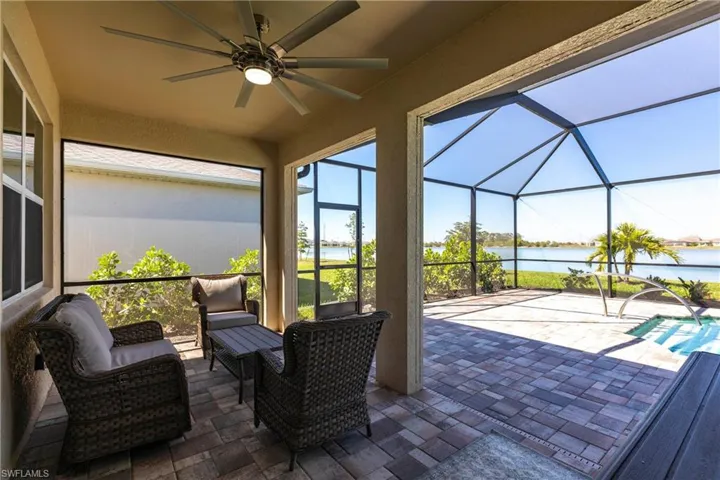 View of patio / terrace with a water view, a lanai, and a ceiling fan