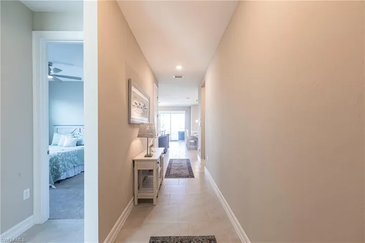 Hallway featuring light tile patterned floors and baseboards