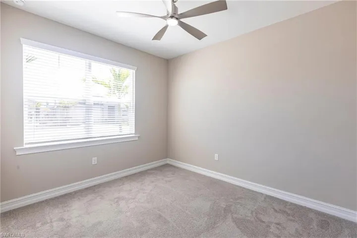 Unfurnished room with light carpet, ceiling fan, and baseboards