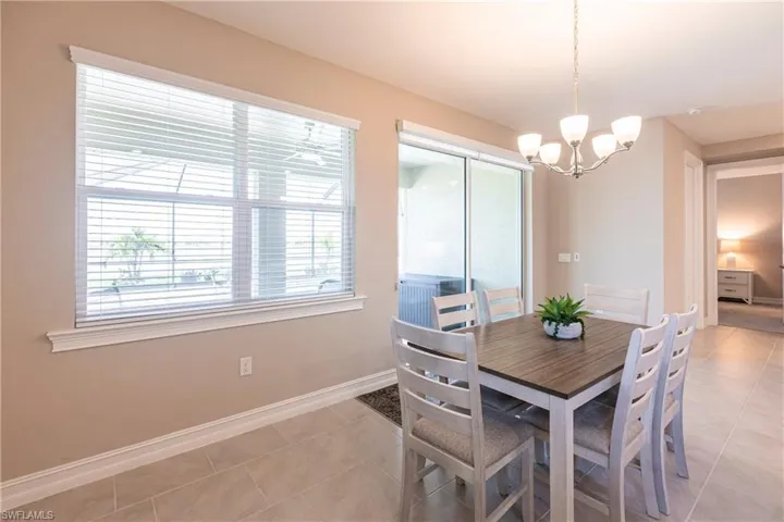 Dining room featuring light tile patterned floors, a chandelier, and baseboards