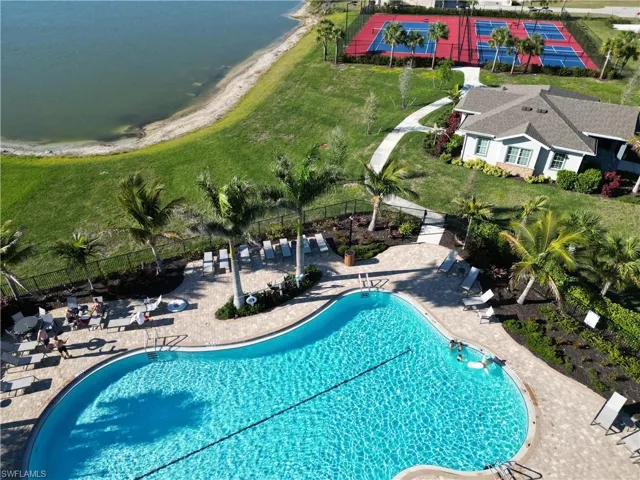 Pool featuring a yard, a patio area, fence, and a water view