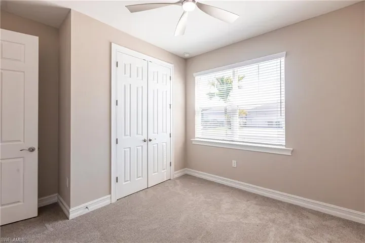 Unfurnished bedroom with ceiling fan, a closet, baseboards, and carpet flooring