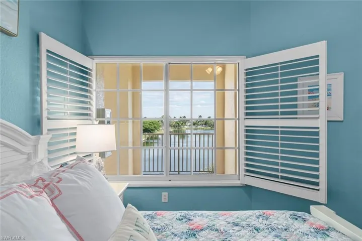 Multi-pane window featuring custom white plantation shutters and water scenery