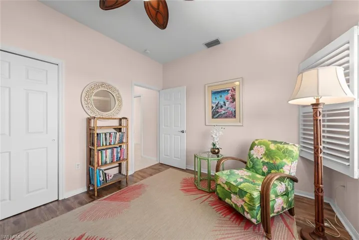 Wood-finish flooring, white six-panel interior doors, adjustable plantation shutters, and an overhead ceiling fan