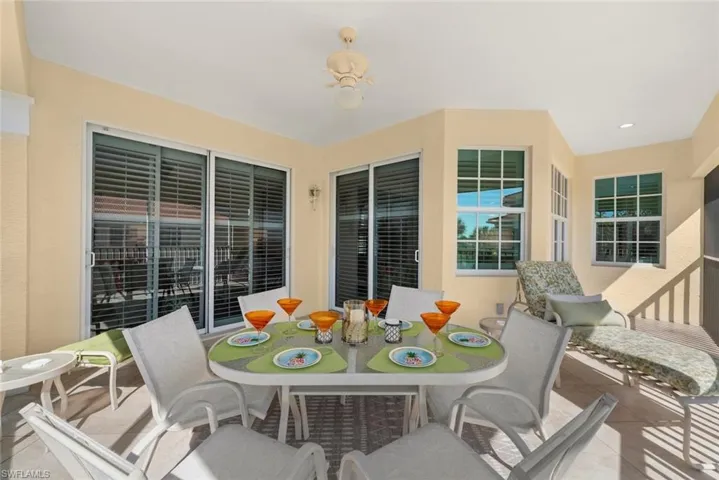 Covered patio featuring tile flooring, multi-pane windows, and dual sliding glass doors