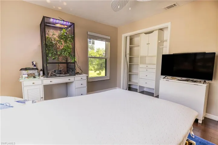 Bedroom featuring dark wood-type flooring, ceiling fan, and a closet