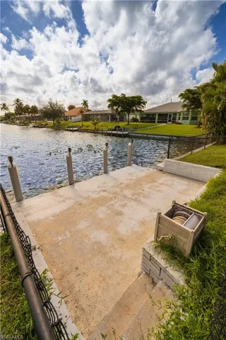 View of dock featuring a water view and a lawn