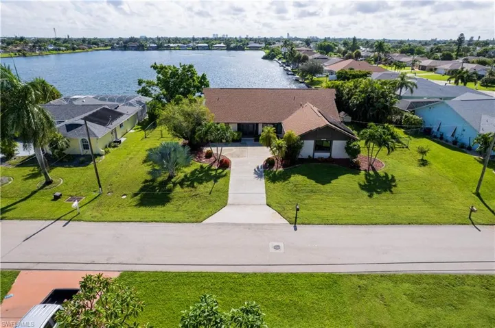 Birds eye view of property with a water view