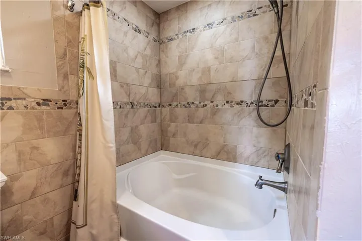Bathroom featuring shower / bath combination with curtain