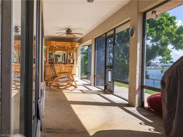 Sunroom / solarium with a water view and ceiling fan