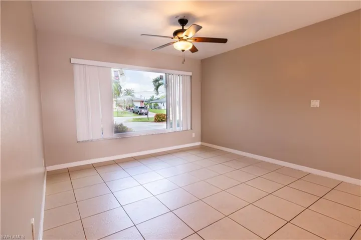 Empty room featuring light tile patterned floors and ceiling fan