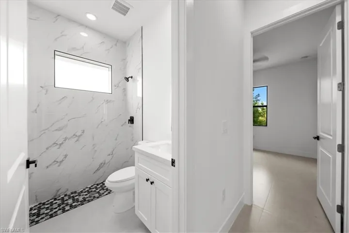 Full bathroom with plenty of natural light, a marble finish shower, vanity, and recessed lighting