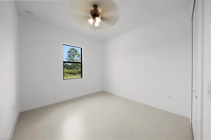 Empty room featuring baseboards and a ceiling fan