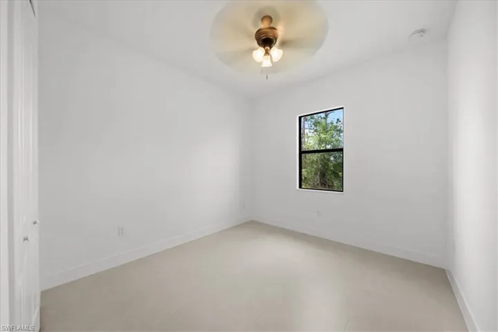Unfurnished room featuring baseboards and a ceiling fan