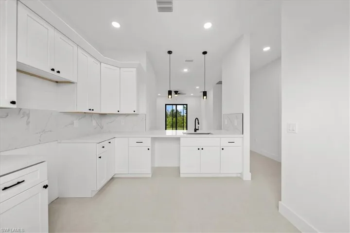 Kitchen featuring white cabinets, tasteful backsplash, decorative light fixtures, recessed lighting, and a ceiling fan