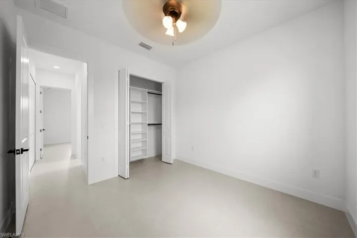 Unfurnished bedroom with a closet, a ceiling fan, and concrete flooring