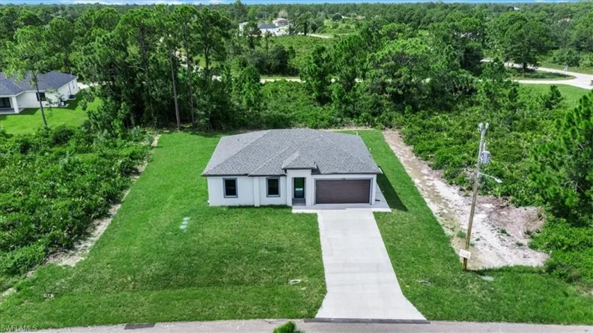 Aerial view of property and surrounding area featuring a heavily wooded area