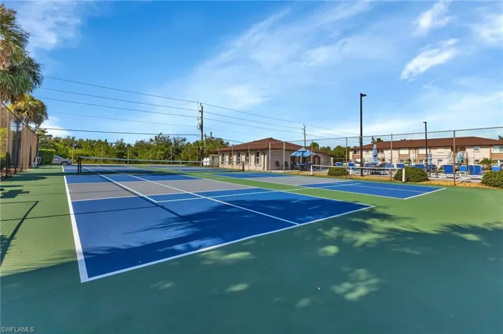 View of tennis court featuring fence