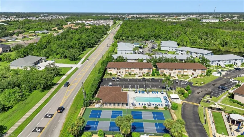 Aerial overview of property's location featuring a pool area and a tree filled landscape