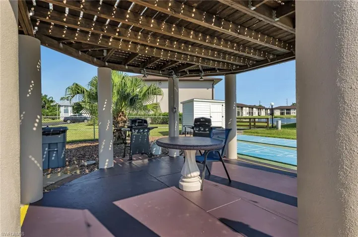 View of patio / terrace with shuffleboard, area for grilling, and a pergola